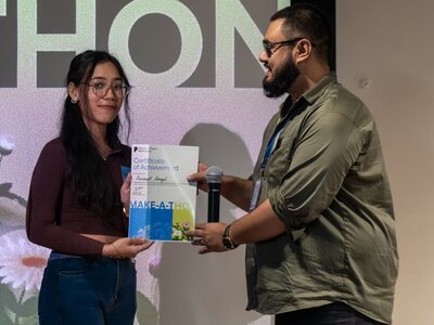 Pradeepti on stage, receiving the Make-a-thon certificate of achievement.